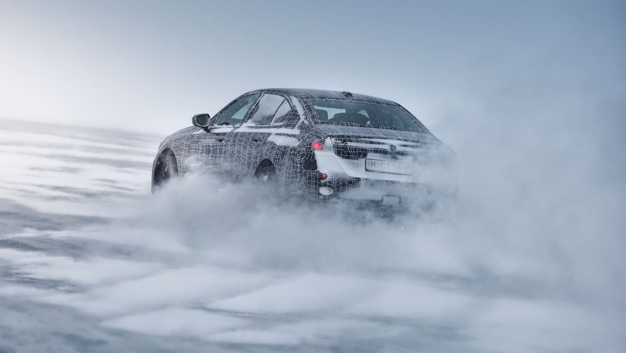 Закамуфлированный BMW i5 на зимних испытаниях (официальное изображение) — задний поворот