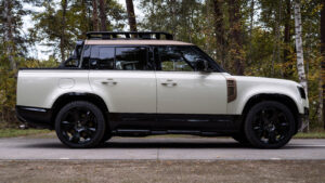 Пикап Land Rover Defender с боковым профилем белого цвета.