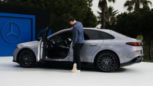 Аластер Крукс смотрит на электромобиль Mercedes C-Class Electric.